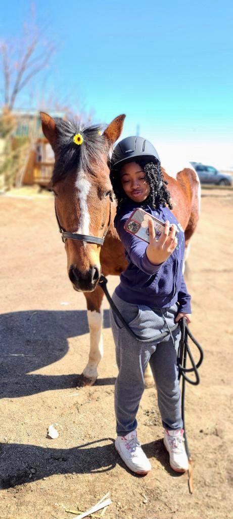 A young rider in a helmet taking a selfie with Bourbon