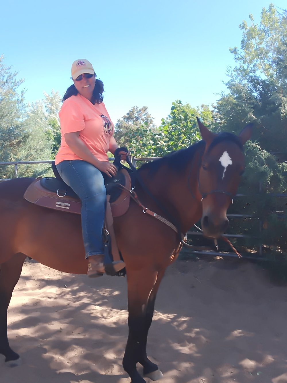 Carla riding Champion, a bay horse with a white star, in the round pen