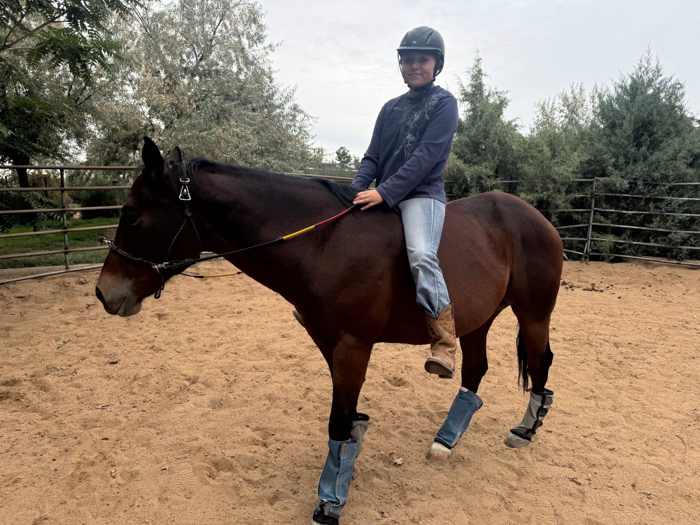 Eloisa riding Champ bareback in the round pen, smiling